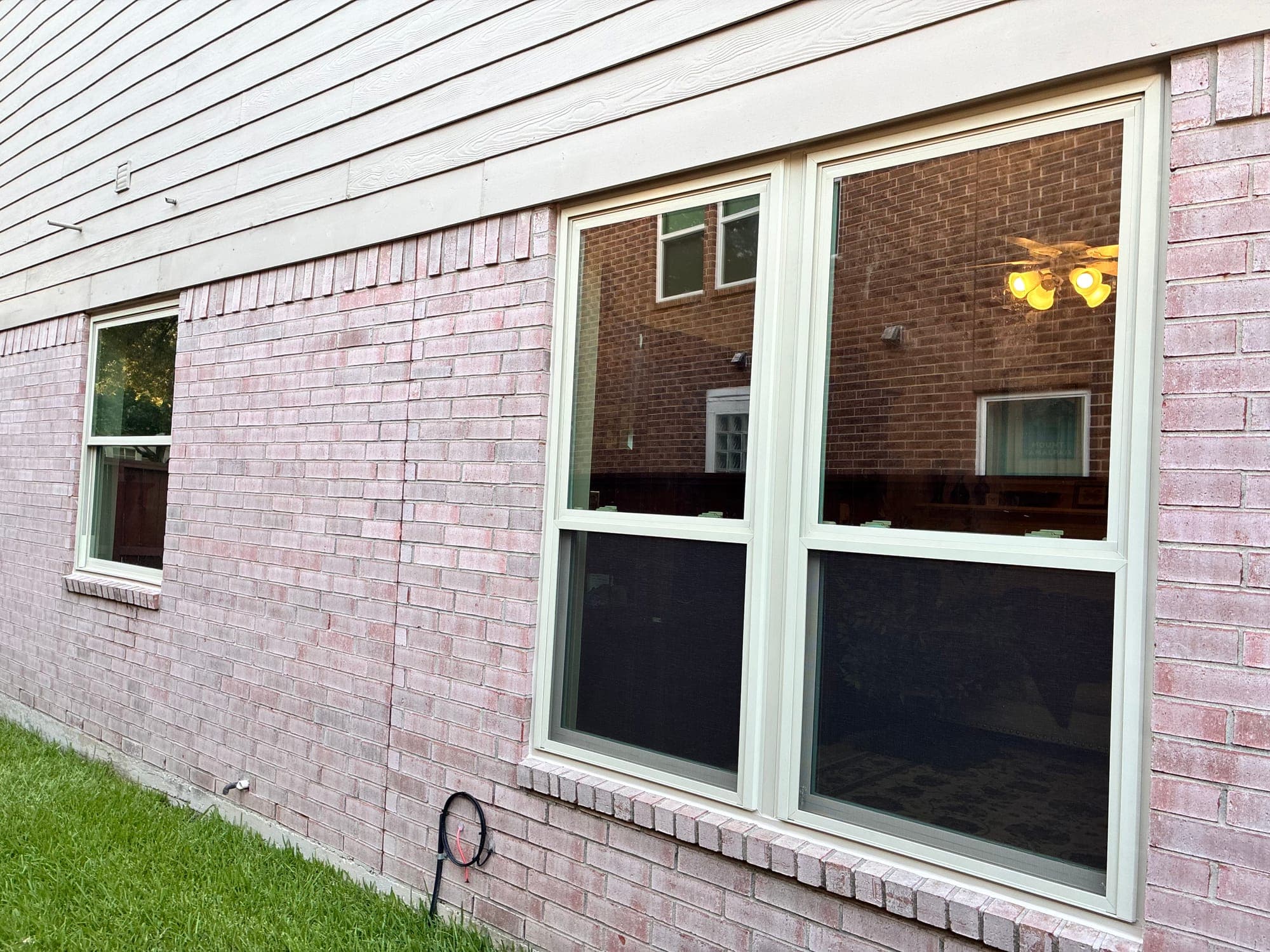 Almond-framed single-hung windows on a blush-brick wall